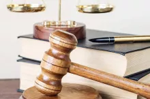 Symbols of law: wood gavel, soundblock, scales and two thick old books