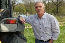 Farmer leaning against tractor