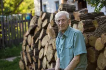 senior man sitting near his rural house
