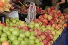 Different types of organic apples at market stall. Fruits on display at farmers market.