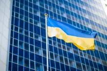 Photo of yellow and blue Ukrainian flag against modern business office building