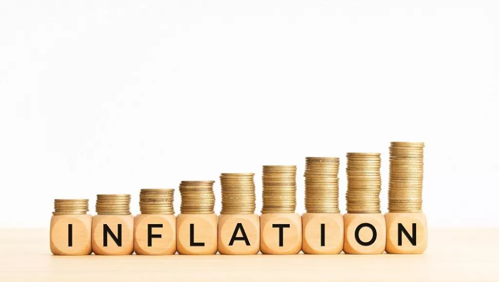 Inflation concept. Text on wooden blocks and stacked coins. Copy space