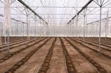 Image of inside of empty greenhouse on a sunny day for preparing the soil for sowing.