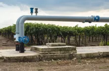 Watering pipes and vineyard. Big irrigation systems.