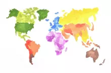The world map is made with colored watercolor paints on white paper. All the world‘s continents are depicted in different colors