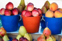 Close up apples and pears in colorful buckets on Russian market