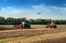 Bilogirya, Khmelnytsky region, UKRAINE - August 19, 2021: tractors with seeder at the demonstration of agricultural machinery, exhibition ”Battle of agrotitans” seeder competition, and airplan at sky