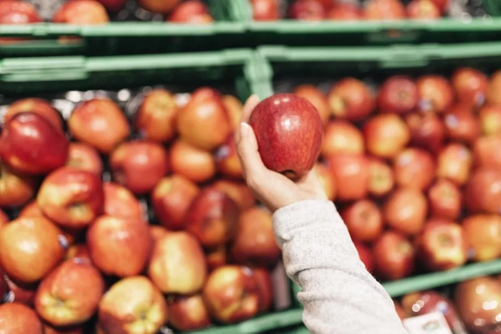 Beautiful woman choosing apples in supermarket. Market food Concept.