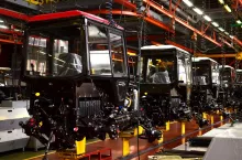 Tractor Manufacture works. Assembly line inside the agricultural machinery factory. Installation of parts on the tractor body. Tractor Manufacturing Facility. Tractors produced