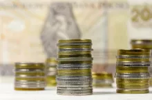 A group of Polish coins arranged next to each other against the background of banknotes, PLN currency, Polish zloty
