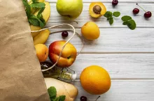 Healthy food background. Healthy food in paper bag, fruits and berries