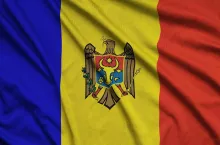 Moldova flag is depicted on a sports cloth fabric with many folds. Sport team waving banner