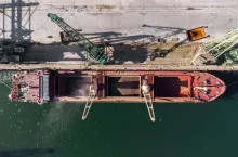 cargo ship loading in port at sunset, aerial view