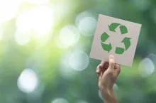 Hand holding recycle symbol on green bokeh background. eco and save the earth concept.