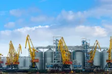 Granary in the Sea Port of Odessa, Ukraine. Portal cranes in the grain terminal with storage containers and silos cisterns in a pier. International transportation and export of agricultural products.