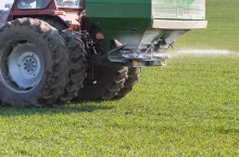 Tractor and fertilizer spreader in field