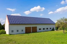 Green energy with solar collectors on the roof of an agricultural building