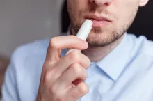&lt;p&gt;Man applying hygienic lipstick on lips to revive chapped lips and avoid dry, closeup. Man use protective cosmetics for care&lt;/p&gt;