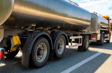 Truck with liquid or oil storage in road or highway of Switzerland. Lorry with service tanker cistern at logistics work. Semi trailer tank. Cargo car drive. Freight delivery. Transport export industry