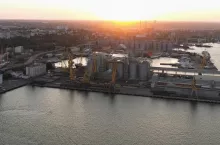 Sea port with tower cranes and grain terminals. Evening sunset light.