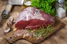 A piece of raw beef on a chopping board. Selective focus.
