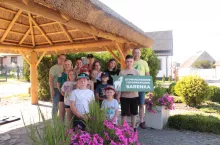 Remigiusz Wojtera (po prawej) z młodymi uczestnikami warsztatów fotograficznych i ich mamami pod wiatą krytą strzechą, na którą sołectwo otrzymało dotację w zeszłorocznej edycji konkursu Pięknieje wielkopolska wieś