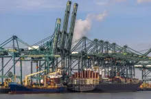 Loading of ships in busy port of Antwerp at container terminal with automated cranes and lots of vessels. Belgium