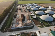 Bio gas factory. Biogas complex on nature landscape. Agricultural plant for biomass production on green field. Modern storage for renewable energy.