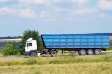 A truck transports grain from the field to the elevator