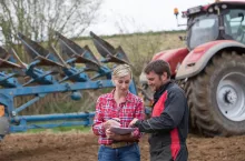 saleswoman try to sell new tractor to farmer