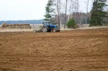 The tractor sows crops, performs agrarian, agricultural, farming, work on the field, land.