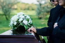 &lt;p&gt;Cropped shot of mature woman and her family in mourning attire standing in front of coffin with closed lid with fresh white chrysanthemums&lt;/p&gt;