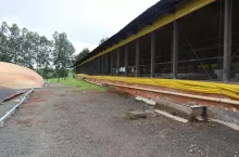 Budynki tuczarni z otwieranymi ścianami, zabezpieczone siatką przed ptakami. Obok chlewni biogazownia.