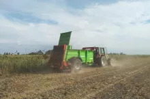 Rolnik rozwożący obornik na polu