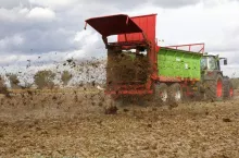 Rozrzucanie obornika na polu przy użyciu specjalistycznej maszyny