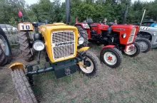 Na zdjęciu widoczne są zabytkowe ciągniki Ursus C-330 w doskonałym stanie technicznym, prezentowane podczas plenerowej wystawy maszyn rolniczych. Modele oznaczone numerami startowymi świadczą o ich udziale w pokazie. Uwagę zwraca klasyczna stylistyka i zachowane oryginalne detale, które przyciągają miłośników dawnej techniki rolniczej.