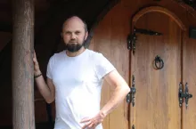 Maciej Piechota przy beczkach-apartamentach. Jeszcze kilka lat temu przechowywano w nich wino. Dziś w takiej mogą się wyspać dwie osoby