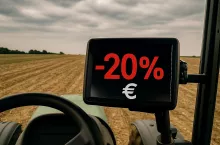 Zdjęcie przedstawia widok z wnętrza kabiny traktora. Na polowym monitorze wyświetla się komunikat ”-20% €”, symbolizujący możliwe zmniejszenie dopłat bezpośrednich w ramach przyszłej Wspólnej Polityki Rolnej UE. W tle widoczne jest wyschnięte, puste pole. To odniesienie do planowanego na lipiec projektu budżetu WPR po 2027 roku i ostrzeżeń europosłów o ryzyku utraty nawet jednej piątej środków przez rolników.