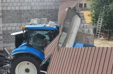 Ciągnik rolniczy, na który spadła ściana budynku garażowego