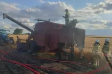 Strażacy podczas akcji gaszenia kombajnu na polu