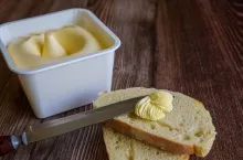 A slice of bread spread with creamy butter.