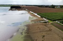 Rozległe zalane pola na Żuławach po intensywnych opadach deszczu, widoczne z lotu drona. Fotografia z profilu Facebook Damiana Murawca (OOPR) pokazuje skalę podtopień, które stały się przedmiotem sporu między rolnikami a Wodami Polskimi.