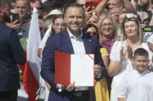 Prezydent RP Karol Nawrocki prezentuje podpisany projekt ustawy ”Ochrona polskiej wsi” podczas wizyty w Krąpielu w powiecie stargardzkim. W tle zgromadzeni mieszkańcy. Zrzut ekranu z transmisji na Facebooku Kancelarii Prezydenta RP.