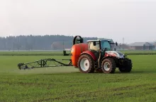 Ciągnik wykonujący oprysk w czasie prac polowych