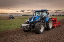 Ciągnik z zaczepionym siewnikiem pracuje w polu