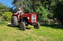 wnuk z dziadkiem na ciągniku rolniczym