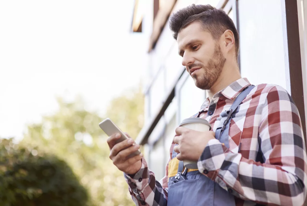 rolnik z telefonem czyta wiadomość SMS