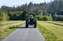 Scene of a old tractor seen from behind on a road in a rural area. Galicia, Spain