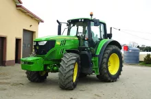 Ciągnik John Deere'a 6155M na placu gospodarstwa rolnego