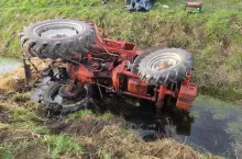 Ciągnik rolniczy na boku w rowie